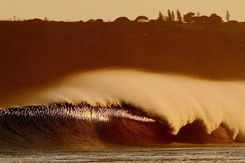 Large wave crashing in the ocean with a sunset or sunrise sky.  Shot in San Diego, California. © Randy Dible Photo