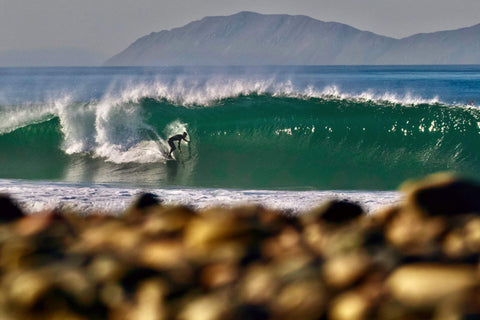 Surfer riding a wave with mountains in the background. Shot in San Diego, California. © Randy Dible Photo